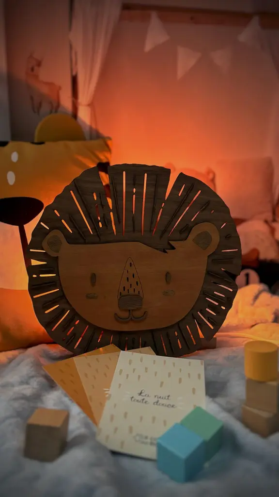 Veilleuse lion en bois allumée diffusant une lumière douce pour le coucher - Le Coffre aux Étoiles